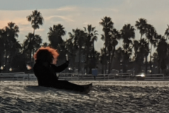 Red-haired-woman-on-beach-taking-selfie