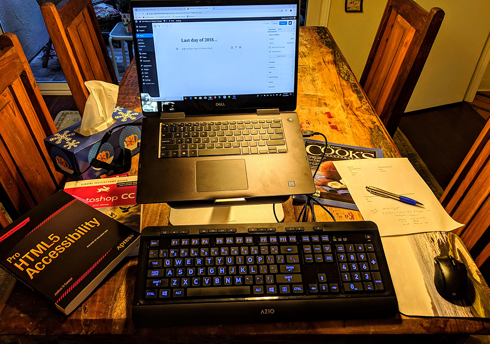 laptop and keyboard with books on a table